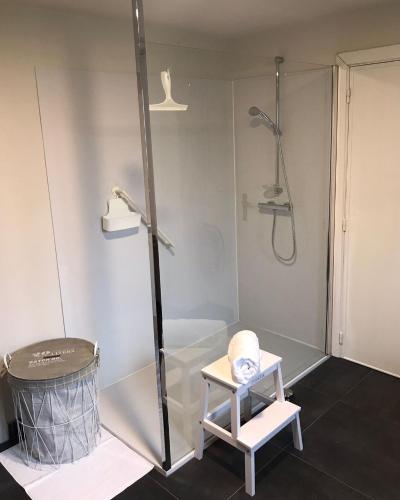 a bathroom with a shower and a stool next to a tub at De Bijenkorf in Damme