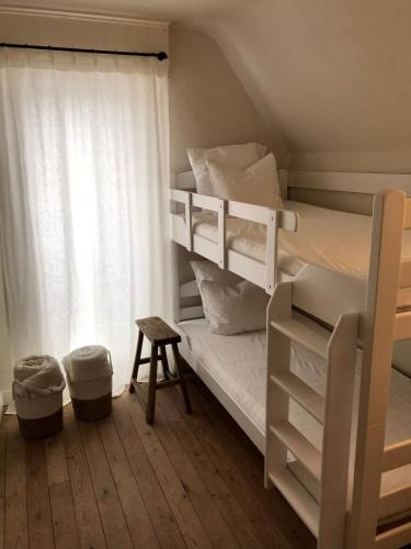 a bedroom with two bunk beds and a window at De Bijenkorf in Damme