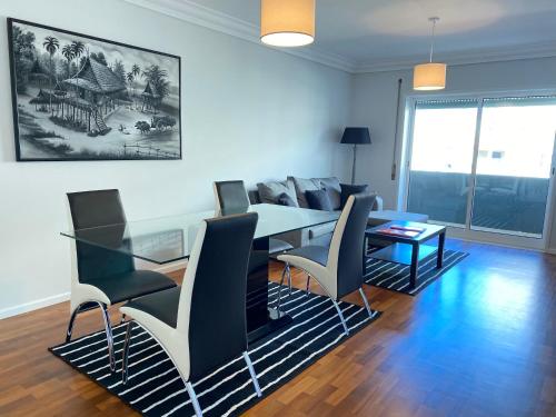 a living room with a dining room table and chairs at OndasDaVagueira - T2 em condomínio com piscina in Gafanha da Boa Hora