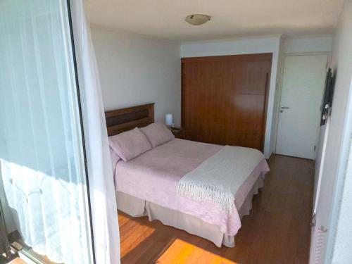 a bedroom with a bed with pink and white sheets at Hermosa vista Iquique in Iquique