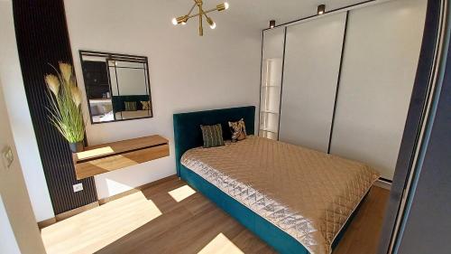 1 dormitorio con 1 cama con cabecero azul en Kima Apartament Bażantów 44, en Katowice
