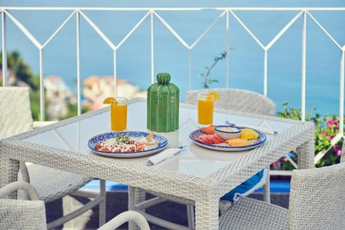 a white table with two plates of food on it at Hotel Luxury Patio Azul in Puerto Vallarta