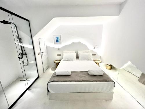una camera da letto con un letto in una stanza bianca di Ananke with Shared Pool a Mykonos Città