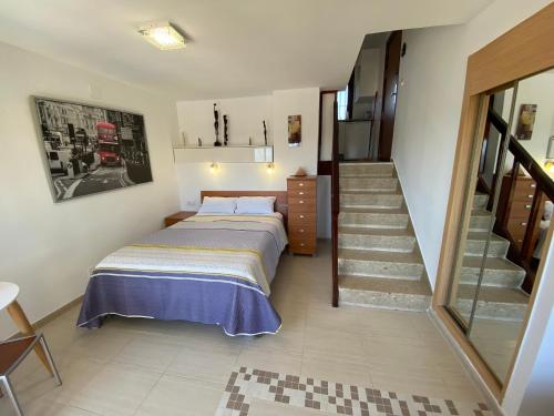 a bedroom with a bed and a staircase in it at Benalmadena ALOHA PLAYA SEA VIEW LOFT in Benalmádena