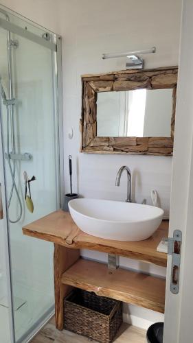 une salle de bain avec un lavabo blanc et un miroir dans l'établissement Gîte Du Soleil Maison lumineuse avec terrasse solarium parking privé, à Sorède