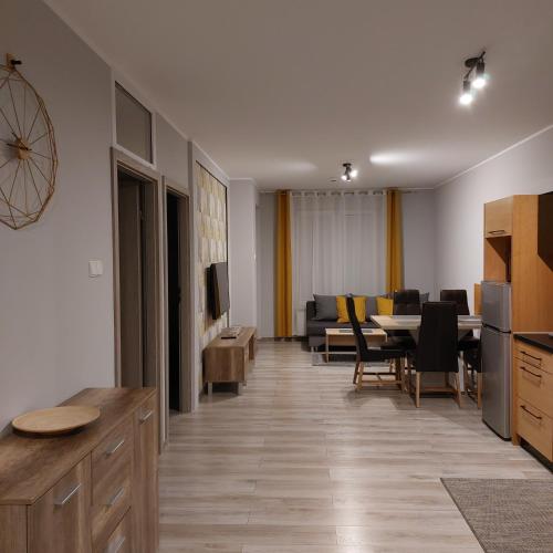 ein Wohnzimmer mit einem Tisch und einem Esszimmer in der Unterkunft Komfortowy apartament w zachodniej części Kołobrzegu in Kołobrzeg
