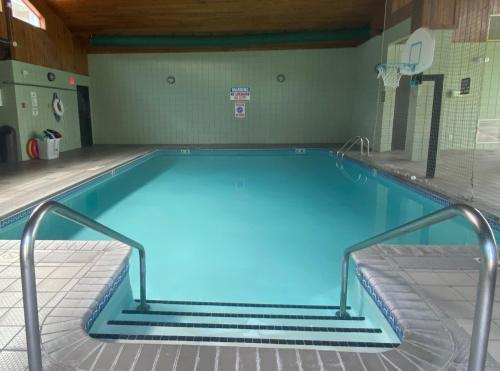 a large swimming pool with blue water in a gym at AmericInn by Wyndham New Richmond in New Richmond