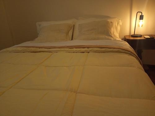 a large white bed with white sheets and pillows at Casa flora Bed and Breakfast in San Juan