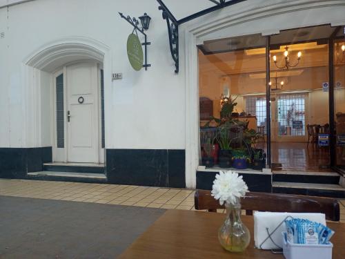 a building with a table with a vase of flowers at Casa flora Bed and Breakfast in San Juan