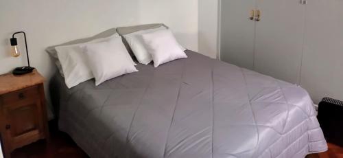 a bedroom with a bed with white pillows at Casa flora Bed and Breakfast in San Juan