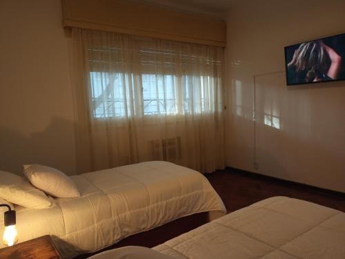 a hotel room with two beds and a window at Casa flora Bed and Breakfast in San Juan