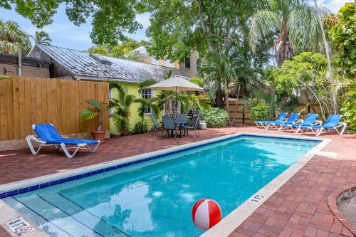 a swimming pool with chairs and a volley ball at Key Lime Calypso in Key West