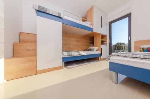 a bedroom with two bunk beds and a window at Resort Banjole - apartman Indigo in Banjole