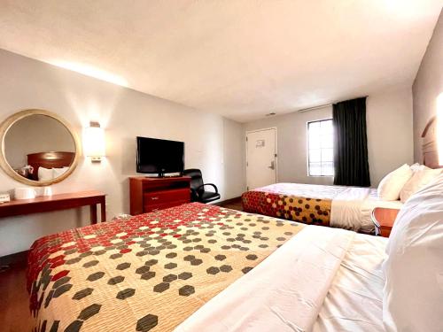 a hotel room with two beds and a flat screen tv at Red Carpet Inn Philadelphia Airport in Lester