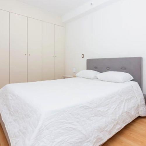 sypialnia z dużym białym łóżkiem z białymi szafkami w obiekcie Apartamento Vacacional con Piscina para Parejas en Panamá 