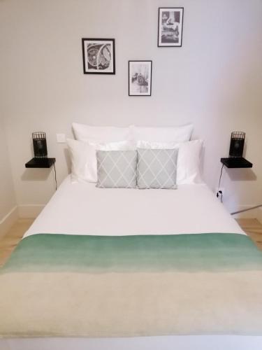 - une chambre avec un grand lit blanc et trois photos sur le mur dans l'établissement LE GREEN 50 m de la plage en baie de Somme, à Cayeux-sur-Mer