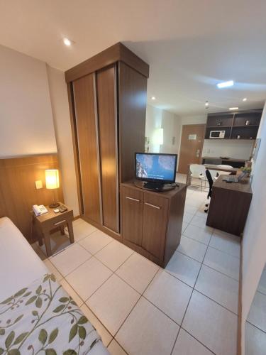 a hotel room with a bed and a tv in a room at Flat Nobile Suítes Monumental By Rei dos Flats, in Brasilia