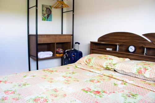 um quarto com uma cama com colcha floral em Perto do Mar, 5G, Ar e Piscina C/Churrasqueira em João Pessoa