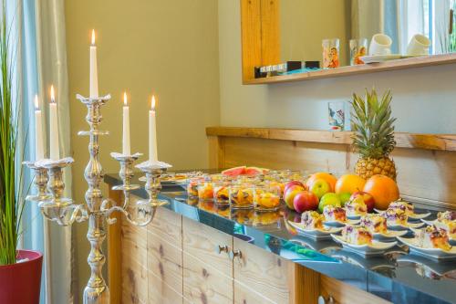 a buffet with fruit on a table with candles at Berghotel Hammersbach in Grainau