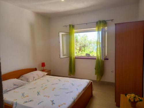 - une chambre avec un lit et une fenêtre avec des rideaux jaunes dans l'établissement Apartman Luka, à Blato