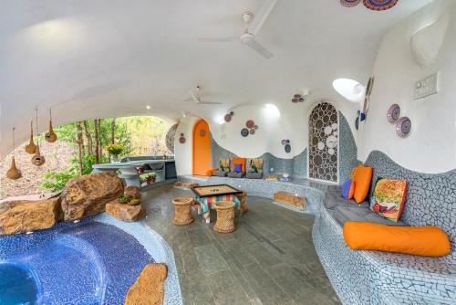 a living room with a pool in the middle of a house at SaffronStays AsanjA Titaly, Murbad - hobbit inspired earth-shelter home with plunge pool in Murbād