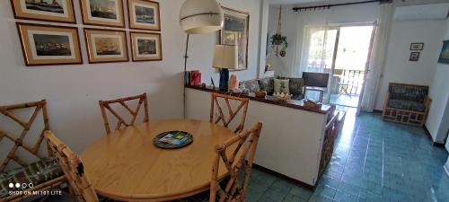 ein Esszimmer mit einem Holztisch und Stühlen in der Unterkunft CASETTA A PORTO ERCOLE in Porto Ercole