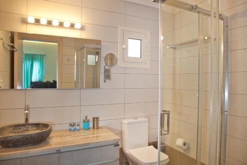 a bathroom with a toilet and a sink and a shower at Porfyra Suite & Spa 1 in Skala