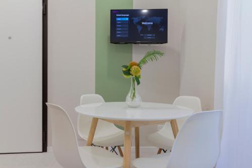 a white table and chairs with a vase of flowers on it at Appartamenti Natura e Terra Marmore in Terni