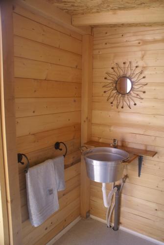 a bathroom with a sink in a wooden wall at Yurta Gaia in Torino di Sangro