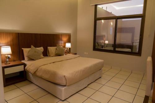a bedroom with a large bed and a window at forsana resort in Dammam