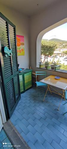 ポルト・エルコレにあるCASETTA A PORTO ERCOLEのテーブル、窓付きのパティオが備わる客室です。
