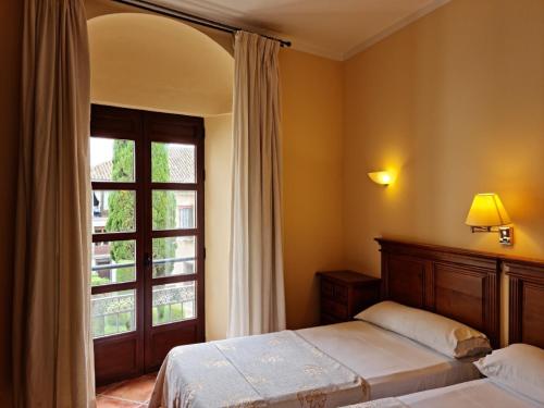 a bedroom with two beds and a window at Hotel Plateros in Córdoba