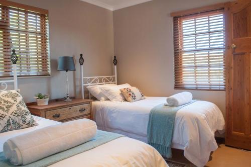 - une chambre avec 2 lits et 2 fenêtres dans l'établissement Somerset Grace Cottage, à Somerset West