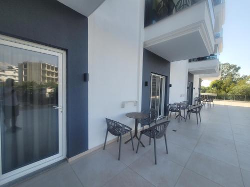 a balcony with chairs and tables on a building at Summer Gate Hotel in Ksamil