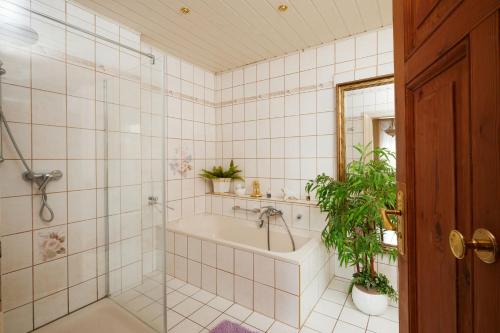 een badkamer met een bad en een douche met planten bij Alte Weberei in Straupitz