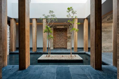a hallway with two trees in a room with pillars at Secrets Moxché Playa del Carmen - Adults Only - All Inclusive in Playa del Carmen