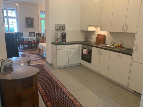 a kitchen with white cabinets and a table in a room at Villa Pazelt Top4 in Bad Vöslau