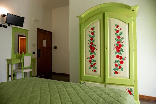 a bedroom with a green bed with red flowers on the wall at La Villetta Food & Drink Rooms for Rent - No Reception - in LʼAquila