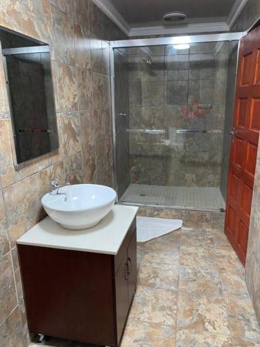 a bathroom with a sink and a shower at Highlands Lodge in Mokoeng