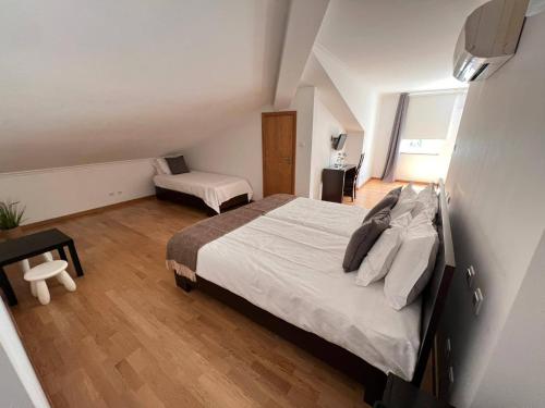um quarto com uma cama grande e uma cadeira em Vale do Zêzere Hotel em Manteigas