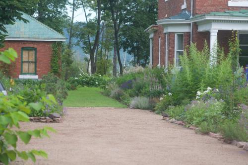 a garden in front of a brick house at Napier House in Campbellton