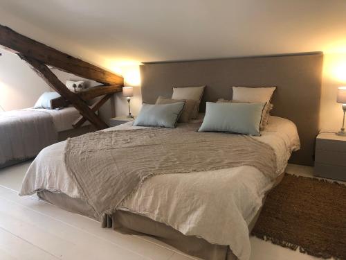 a bedroom with a large bed with two pillows at Val du Lys in Sainte-Maure-de-Peyriac