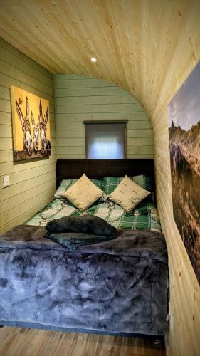 a bedroom with a large bed in a room at Emlyn's Coppice - Luxury Woodland Glamping in Holywell