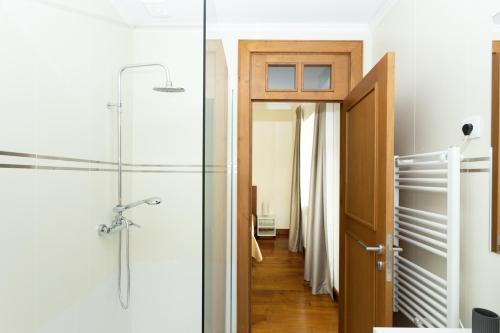 a bathroom with a shower and a glass door at Countryside Villa with Nature & Pool - 'Casa dos Vasconcelos' in Chaves