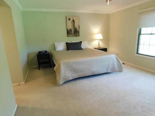 a bedroom with a large bed and a window at Office + 5 BR, Movie Theater , Creve Coeur -10 Sleep surface in Creve Coeur