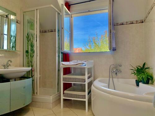 a bathroom with a tub and a sink and a bath tub at DISNEY & PARIS Happy Villa for 10 persons with Private Garden & Terrace 4 bedrooms, 3 bathrooms FIBER Wifi Netflix & free Parking in Bailly-Romainvilliers