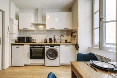 a kitchen with white cabinets and a washer and dryer at Nice and modern flat at the heart of Panier in Marseille - Welkeys in Marseille