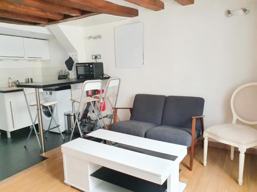 salon z kanapą i stołem w obiekcie EXIGEHOME-Studio Cosy à 2 pas du Chateau de Versailles w Wersalu