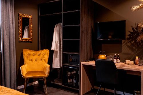 a room with a desk and a yellow chair at Othmar Herberg in Ootmarsum