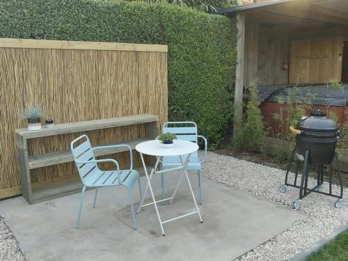 a patio with a table and chairs and a grill at Sea You Soon privé kamer met jacuzzi en sauna in Bredene